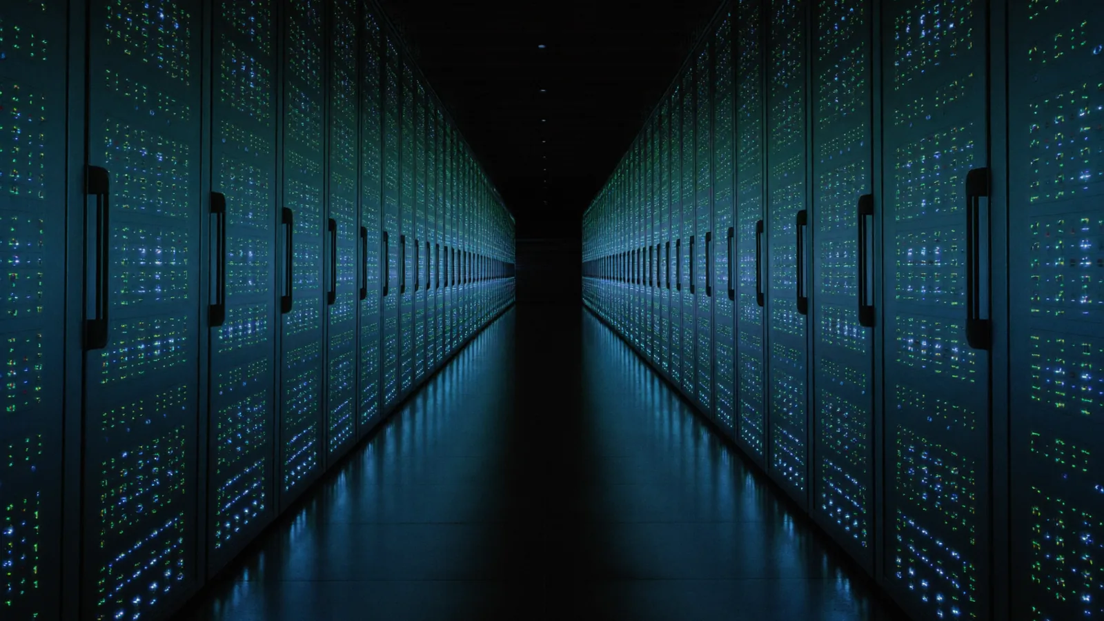 Symmetrical view down the aisle between two rows of server racks, status lights receding into the dark.